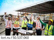 Construction engineers, architects, and foremen form a group. Participate in a meeting to plan new construction projects. Cheers to express happiness that the event was successfully accomplished. Стоковое фото, агентство Ingram Publishing / Фотобанк Лори