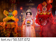 Chinese woman with yellow and red lions It is considered to enhance the prosperity for oneself on the occasion of the Chinese New Year festival every year and in Chinese, it means prosperous, fortunate, happy, prosperous. Стоковое фото, агентство Ingram Publishing / Фотобанк Лори