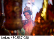 Chinese woman make wishes, pray, and light candles. On the occasion of the annual Chinese New Year festival, in a revered shrine or temple. Стоковое фото, агентство Ingram Publishing / Фотобанк Лори