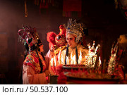 Male and female Chinese opera actors Light a candle to pray homage to the gods to enhance the prosperity for yourself on the occasion of the Chinese New Year festival. Стоковое фото, агентство Ingram Publishing / Фотобанк Лори
