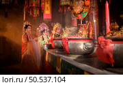 Male and female Chinese opera actors Light a candle to pray homage to the gods to enhance the prosperity for yourself on the occasion of the Chinese New Year festival. Стоковое фото, агентство Ingram Publishing / Фотобанк Лори