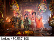 Male and female Chinese opera actors Light a candle to pray homage to the gods to enhance the prosperity for yourself on the occasion of the Chinese New Year festival. Стоковое фото, агентство Ingram Publishing / Фотобанк Лори