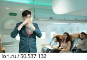 Flight attendants show how to use safety devices and recommend emergency exits. Стоковое фото, агентство Ingram Publishing / Фотобанк Лори