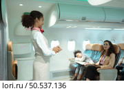 Flight attendants show how to use safety devices and recommend emergency exits. Стоковое фото, агентство Ingram Publishing / Фотобанк Лори