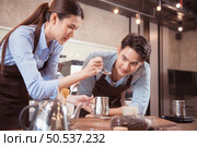 Before competing in the championship level coffee brewing competition, both of the baristas practice their coffee latte makeup techniques to become proficient. Стоковое фото, агентство Ingram Publishing / Фотобанк Лори