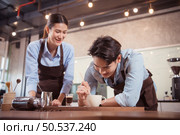 Before competing in the championship level coffee brewing competition, both of the baristas practice their coffee latte makeup techniques to become proficient. Стоковое фото, агентство Ingram Publishing / Фотобанк Лори