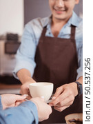 Young barista with the intention of making up a latte coffee to satisfy customers both in appearance and taste, This cup of coffee is ready to be served. Стоковое фото, агентство Ingram Publishing / Фотобанк Лори
