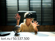 Portrait of little girl in office room of house with gestures that are expressed when playing virtual reality games. Стоковое фото, агентство Ingram Publishing / Фотобанк Лори