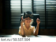 Portrait of little girl in office room of house with gestures that are expressed when playing virtual reality games. Стоковое фото, агентство Ingram Publishing / Фотобанк Лори