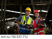 The foreign chief engineer came to inspect the old mechanical factory. There is an African female mechanic explaining details and progress reports on old machines being repaired to restore normal operation. Стоковое фото, агентство Ingram Publishing / Фотобанк Лори