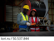 Two technicians Inspecting and testing the operation of lifting cranes in heavy industrial plants. Стоковое фото, агентство Ingram Publishing / Фотобанк Лори