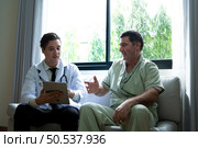 A young doctor who specializes in heart disease. Report and advise patients with symptoms of heart disease. that the results of the treatment improved until they were able to go home tomorrow. Стоковое фото, агентство Ingram Publishing / Фотобанк Лори