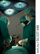 Professor of medicine in cardiology and a team of doctors in the operating room undergoing heart transplant surgery. Стоковое фото, агентство Ingram Publishing / Фотобанк Лори