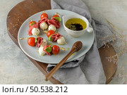 Italian style appetizer, antipasto skewer or caprese on a stick with basil, salami, mozarella and tomatoes. Стоковое фото, агентство Ingram Publishing / Фотобанк Лори