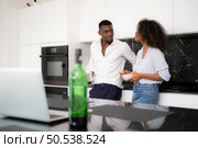 Both of young couple discussing business in the kitchen at home using laptop computers. Стоковое фото, агентство Ingram Publishing / Фотобанк Лори