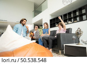 Multiethnic group of friends having fun playing guitar and singing together at home. Стоковое фото, агентство Ingram Publishing / Фотобанк Лори