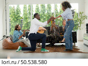 A group of multiethnic friends having fun at a party and witness their friend’s marriage proposal. Стоковое фото, агентство Ingram Publishing / Фотобанк Лори