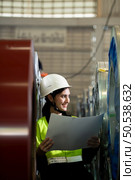 Portrait of a heavy equipment female engineer from a huge industry who came to inspect the metal sheet factory’s machinery. Стоковое фото, агентство Ingram Publishing / Фотобанк Лори