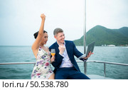 On a yacht, a businessman begins his family’s vacation. a huge project agreement was successfully closed, which was wonderful news. Стоковое фото, агентство Ingram Publishing / Фотобанк Лори