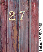 Number 27 on red painted old wooden wall. Red background. Стоковое фото, агентство Ingram Publishing / Фотобанк Лори