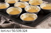 Egg tarts, traditional portuguese dessert, pastel de nata, custard tarts during home production on metal tray. Стоковое фото, агентство Ingram Publishing / Фотобанк Лори