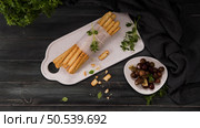 Fresh baked homemade grissini bread sticks in white ceramic tray with olive oil and basil herbs over kitchen counter top. Стоковое фото, агентство Ingram Publishing / Фотобанк Лори