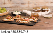 Canape or crostini with multigrain  crispread with cream cheese and fig jam on a slate board. Delicious appetizer ideal as an aperitif. Стоковое фото, агентство Ingram Publishing / Фотобанк Лори