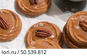 Caramel cookies with pecan nuts served on roud plates, in the kitchen after baking. Стоковое фото, агентство Ingram Publishing / Фотобанк Лори