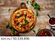 Pizza Margherita on a wooden background. Стоковое фото, агентство Ingram Publishing / Фотобанк Лори