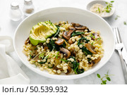 Couscous with avocado, spinach and sauteed champignon mushrooms with onion. Стоковое фото, агентство Ingram Publishing / Фотобанк Лори
