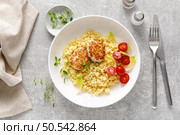 Couscous with chicken patties, cutlets and tomatoes, top down view. Стоковое фото, агентство Ingram Publishing / Фотобанк Лори