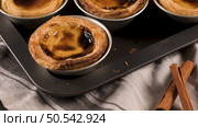 Rows of freshly cooked egg tarts, traditional portuguese dessert, pastel de nata, custard tarts on metal tray. Стоковое фото, агентство Ingram Publishing / Фотобанк Лори
