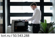 Businessman in office working with copier. Стоковое фото, агентство Ingram Publishing / Фотобанк Лори