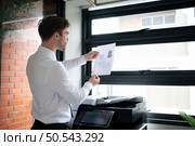 Businessman in office working with copier. Стоковое фото, агентство Ingram Publishing / Фотобанк Лори