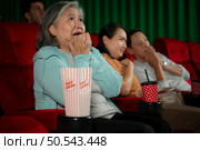 When watching scary ghost movies in theaters, moviegoers appear terrified. Стоковое фото, агентство Ingram Publishing / Фотобанк Лори