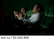 Family members of an Asian senior woman clap their hands for the movies she watches with the impression. Стоковое фото, агентство Ingram Publishing / Фотобанк Лори
