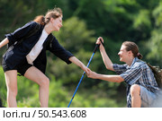 Young couple hiking in the forest with backpacks and trekking poles. Стоковое фото, агентство Ingram Publishing / Фотобанк Лори