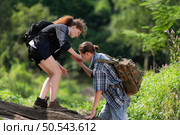 Young couple hiking in the forest with backpacks and trekking poles. Стоковое фото, агентство Ingram Publishing / Фотобанк Лори