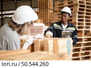 Young female and male warehouse workers using digital tablet for working in wooden factory, Checking the neatness of the planks. Стоковое фото, агентство Ingram Publishing / Фотобанк Лори