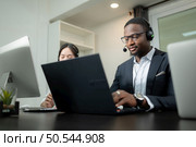 Group of business people wearing headset working actively in office. Call center, telemarketing, customer support agent provide service on telephone video conference call. Стоковое фото, агентство Ingram Publishing / Фотобанк Лори