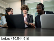 Group of business people wearing headset working actively in office. Call center, telemarketing, customer support agent provide service on telephone video conference call. Стоковое фото, агентство Ingram Publishing / Фотобанк Лори