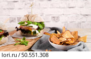 Healthy vegan burger with fresh vegetables and yogurt sauce on rustic kitchen counter top. Стоковое фото, агентство Ingram Publishing / Фотобанк Лори