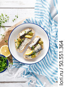 Sardines sandwiches on a white wooden background. Mediterranean food. Top view. Стоковое фото, агентство Ingram Publishing / Фотобанк Лори