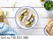 Sardines sandwiches on a white wooden background. Mediterranean food. Top view. Стоковое фото, агентство Ingram Publishing / Фотобанк Лори
