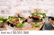 Healthy vegan burger with fresh vegetables and yogurt sauce on rustic kitchen counter top. Стоковое фото, агентство Ingram Publishing / Фотобанк Лори