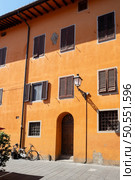 Brightly painted house in orange. Stunning colorful background. Pisa, Italy. Stunning colorful background. Стоковое фото, агентство Ingram Publishing / Фотобанк Лори
