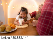 A plus-size family with a father wearing a prosthetic leg, Eat together after cooking and daughter drinks milk for health in the dining room of the house. Стоковое фото, агентство Ingram Publishing / Фотобанк Лори