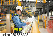 Electric vehicle engineer with blueprints prepare to inspect electric train machinery according to the inspection cycle. Before the electric train enters the train repair tracks. Стоковое фото, агентство Ingram Publishing / Фотобанк Лори