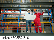 Portrait of two engineer discussing blueprints of electric train machinery Before undergoing regular inspection after being used for transporting passengers for a period of time. Стоковое фото, агентство Ingram Publishing / Фотобанк Лори