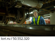 Engineers for electric trains After detecting difficulties with the electric train’s machinery use searchlights to locate and check damaged sections. In the electric train repair shop. Стоковое фото, агентство Ingram Publishing / Фотобанк Лори